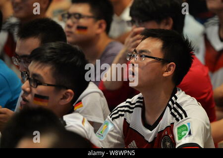 Soccer fans chinois portant des maillots de football de l'équipe nationale Allemagne regarder le match final de la Coupe du Monde de la FIFA 2014 entre l'Allemagne et l'Argentine à un Banque D'Images