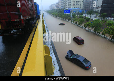 Les véhicules sont bloqués par les inondations causées par des pluies torrentielles sur une route dans la ville de Shenzhen, province de Guangdong, en Chine du sud 11 mai 2014. Au moins trois personnes Banque D'Images