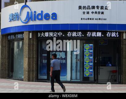 --FILE--un piéton passe devant un magasin de Midea Yichang city, province de Hubei, Chine centrale 9 octobre 2013. Chinese home appliance retailer Midea Banque D'Images