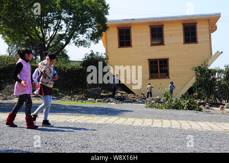 Deux filles passent devant une maison à l'envers en construction à China Folk Village de peinture ancienne ville 1051 Cidu, Jinshan District, Shangha Banque D'Images