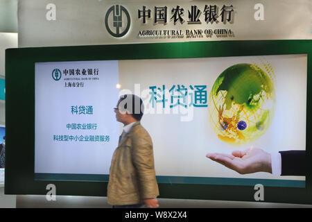 --FILE--un piéton passe devant une publicité pour la Banque agricole de Chine (ABC) à Shanghai, Chine, le 25 avril 2014. Banque agricole de Ch Banque D'Images