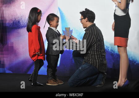 L'acteur américain Johnny Depp, deuxième à droite, reçoit un don de deux jeunes enfants lors d'une conférence de presse pour son film, la transcendance, à Beijing, Chine, 3 Banque D'Images