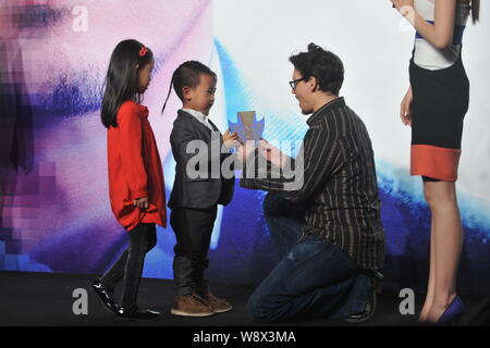 L'acteur américain Johnny Depp, deuxième à droite, reçoit un don de deux jeunes enfants au cours d'une conférence de presse pour son film, la transcendance, à Beijing, le Menton Banque D'Images