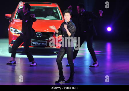 Chanteuse et actrice chinoise Li Yuchun, avant, effectue au cours d'une cérémonie de lancement pour voitures Mazda Atenza dans Beijing, Chine, 6 mai 2014. Banque D'Images