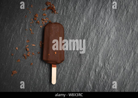 Ice cream stick avec l'écrou d'amandes sur fond sombre , plat lay / ice cream chocolat congelé bâtons couverts Banque D'Images