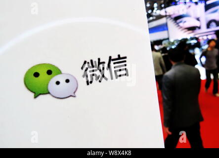 --FILE--Visiteurs devant une pancarte de la messagerie mobile app Weixin, ou de Tencent WeChat, lors d'une exposition à Shanghai, Chine, le 25 avril 2013. Banque D'Images