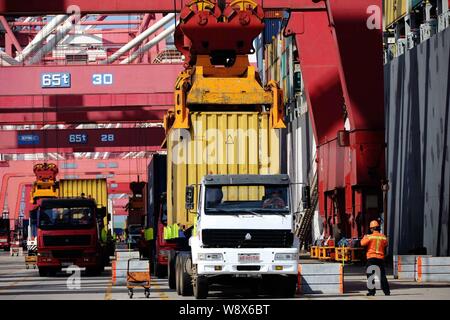 --FILE--une grue véhicule charge un conteneur pour être expédiés à l'étranger, d'un camion au port de Qingdao en Qingdao city, province du Shandong, Chine de l'est 8 J Banque D'Images