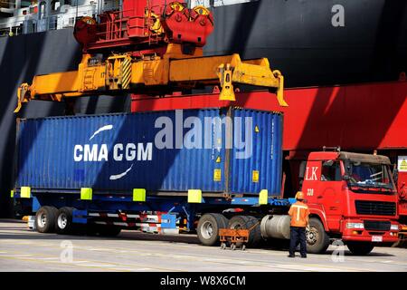 --FILE--une grue véhicule charge un conteneur de CMA CGM à être expédiés à l'étranger, d'un camion au port de Qingdao en Qingdao Shandong, Chine de l'est pr Banque D'Images