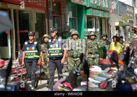 Les agents de police et paramilitaires chinois patrouille de policiers dans une rue de la ville de Kashgar, dans la région autonome du Xinjiang Uygur Chines, 23 juillet 2014. Banque D'Images