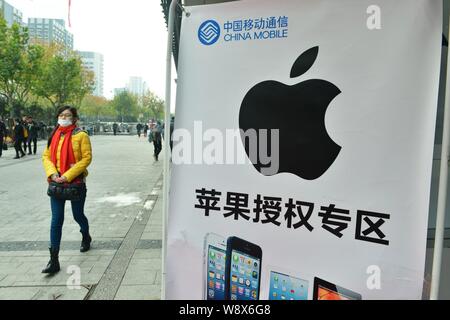 --FILE--un piéton passe devant une publicité pour l'iPhone 5s d'Apple dans les smartphones, à l'est de la ville de Hangzhou dans la province du Zhejiang, Chine 18 décembre 2013. Banque D'Images