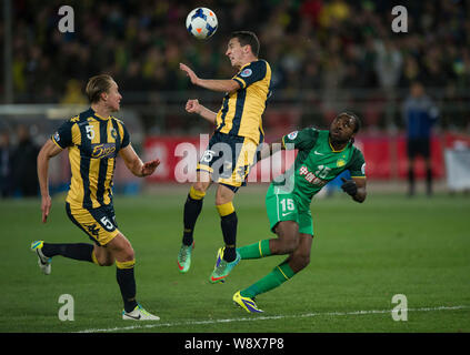 Storm Roux d'Australias Central Coast Mariners, centre, les chefs la balle à côté de son coéquipier Zac Anderson, à gauche, et Peter Maduabuchi Utaka de Chines Banque D'Images