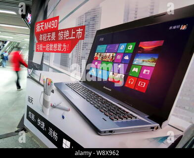 --FILE--un piéton passe devant une publicité pour les ordinateurs portables Lenovo à une station de métro à Shanghai, Chine, le 27 janvier 2013. Le Groupe Lenovo Lt Banque D'Images