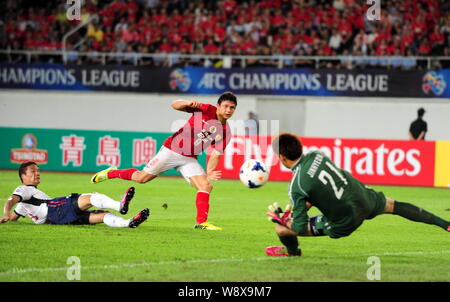 Elkeson de Guangzhou Evergrande Chines, centre, tire contre le Cerezo Osaka dans leur deuxième étape de la ronde de 16 au cours de l'AFC Champion 2014 Banque D'Images