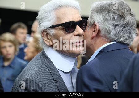 Créateur de mode allemand Karl Lagerfeld, gauche, accueille un invité au Défilé Dior Homme durant la saison printemps/été 2015 Paris Mens Fashion Week à Paris Banque D'Images