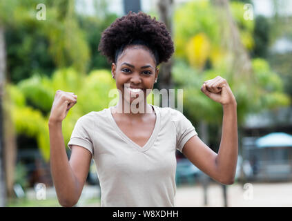 Cheering Caraïbes femme aux cheveux afro en plein air l'été Banque D'Images