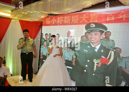 Liang Tao, droite, le chef de l'armée de frontière dans la vidéo, propose des toasts avec son épouse Yang Xiaoting vidéo pendant leur cérémonie de mariage dans un hôtel je Banque D'Images