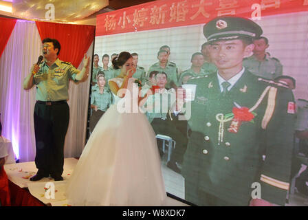 Liang Tao, droite, le chef de l'armée de frontière dans la vidéo, propose des toasts avec son épouse Yang Xiaoting vidéo pendant leur cérémonie de mariage dans un hôtel je Banque D'Images