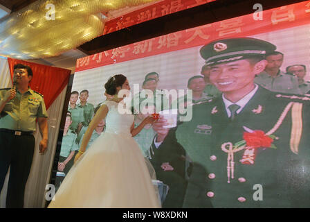 Liang Tao, droite, le chef de l'armée de frontière dans la vidéo, propose des toasts avec son épouse Yang Xiaoting vidéo pendant leur cérémonie de mariage dans un hôtel je Banque D'Images