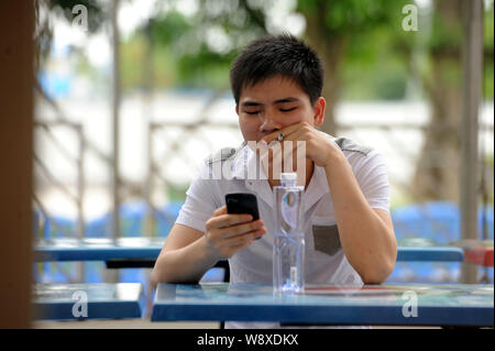 --FILE--un Chinois fume une cigarette à une cantine dans la ville de Guangzhou, province de Guangdong, en Chine du sud 29 mai 2013. La Chine envisage de sensibiliser Banque D'Images