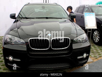 --FILE--un visiteur regarde une BMW X6 SUV à un auto show de Yichang city, province de Hubei, Chine centrale 22 septembre 2012. Constructeur automobile allemand BMW AG s Banque D'Images