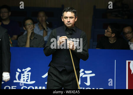 Alan McManus d'Écosse les craies son cue qu'il estime une tourné contre Stephen Maguire d'Écosse au cours de leur deuxième match de la World 2014 S Banque D'Images