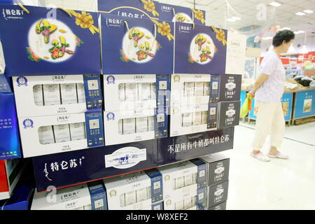 --FILE--un client chinois marche dernières cartouches de lait Mengniu dans un supermarché de luxe à Shanghai, Chine, le 2 septembre 2014. China Mengniu Dairy Co's Banque D'Images