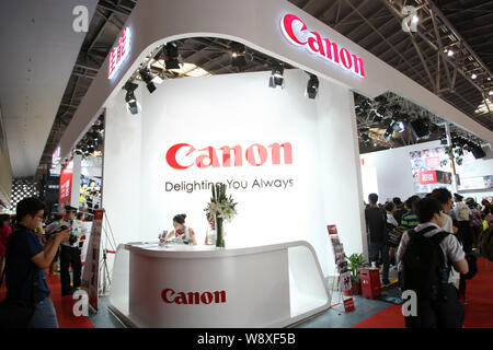 --FILE--personnes visitent le stand de canon lors de la 16e Photo et imagerie Shanghai 2014 Exposition universelle de Shanghai, Chine, le 5 juillet 2014. Bookworms chinois Banque D'Images
