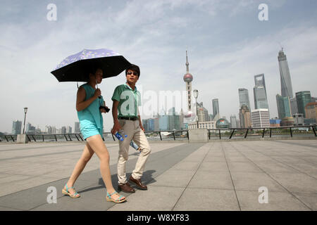 Les protections d'une femme elle-même avec un parapluie d'un soleil de plomb à la promenade sur le Bund à Shanghai, Chine, 27 mai 2014. Les gens essaient différents w Banque D'Images