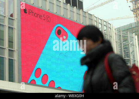 --FILE--un piéton passe devant une publicité pour les smartphones iPhone 5c d'Apple à Shanghai, Chine, le 28 janvier 2014. Apple a mis en place son f Banque D'Images