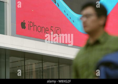 --FILE--un piéton passe devant une publicité pour les smartphones iPhone 5c d'Apple à Shanghai, Chine, le 28 janvier 2014. L'iPhone d'Apple 5C, le Lowe Banque D'Images