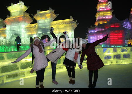 Les visiteurs posent pour des photos en face de sculptures sur glace à la 30e Harbin International Ice and Snow Festival dans la ville de Harbin, au nord-est de porcelaines Heilongjia Banque D'Images