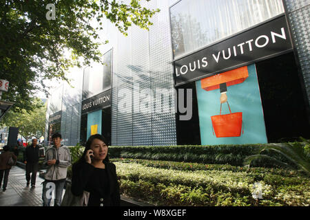 --FILE--piétons devant une boutique de mode de Louis Vuitton (LV) à Shanghai, Chine, 28 octobre 2013. Produits de luxe LVMH Moet Hennessy leader Loui Banque D'Images