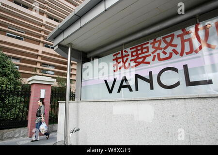 --FILE--un piéton passe devant une publicité pour Vancl à Shanghai, Chine, 21 octobre 2013. La marque de mode chinois et e-tailer Vancl annoncé je Banque D'Images