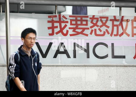 --FILE--un piéton passe devant une publicité pour Vancl à Shanghai, Chine, 21 octobre 2013. La marque de mode chinois et e-tailer Vancl annoncé je Banque D'Images