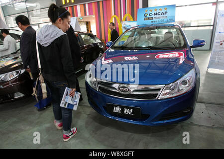 --FILE--visiteurs voir berlines BYD Auto lors d'un show à Shanghai, Chine, le 19 novembre 2013. Fabricant automobile chinois BYD est à la recherche d'investir jusqu'à 100 mi Banque D'Images