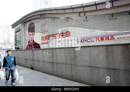 --FILE--un piéton passe devant une publicité pour Vancl à Shanghai, Chine, 21 octobre 2013. La marque de mode chinois et e-tailer Vancl annoncé je Banque D'Images