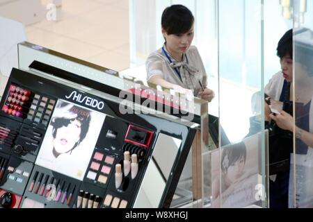 ---Fichier-clients chinois acheter Shiseido et les produits de beauté à un centre commercial à Shanghai, Chine, 24 août 2011. Les cosmétiques japonais mak Banque D'Images