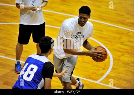 Un stagiaire défis joueur de basket-ball américain Anthony Davis, droite, pendant une session de formation du camp de basket-ball Nike 2014 All-Asia à Guangzhou Banque D'Images