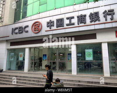 --FILE--piétons passent devant une succursale de l'ICBC (Industrial and Commercial Bank of China) à Chongqing, Chine, le 20 juillet 2014. Les secteurs industriel et Comm Banque D'Images