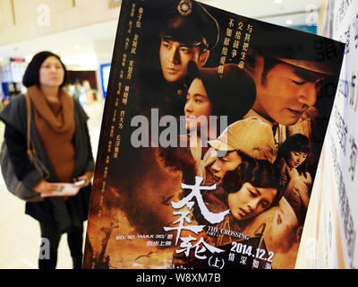 --FILE--une moviegoer chinois passe devant une affiche pour le film 'Le passage' dans un cinéma du centre de la Chine, la ville de Yichang, province de Hubei, du 2 au 2 décembre Banque D'Images