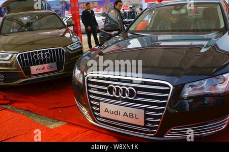 --FILE--visiteurs regarder ou essayer une Audi A8L au cours d'une exposition d'automobiles dans la ville de Yichang, province de Hubei, Chine centrale, du 22 décembre 2012. Banque D'Images