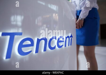 --FILE--un employé passe devant le stand de Tencent lors d'une exposition à Beijing, Chine, 11 mai 2012. Woqu, une agence de voyage en ligne pour l chinois Banque D'Images