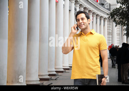College boy talking on a mobile phone and smiling Stock Photo