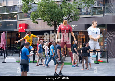 Les visiteurs passent devant trois chiffres géant du football superstars (de gauche) du Brésil, Neymar Cristiano Ronaldo du Portugal et l'Angleterre de Wayne Rooney Banque D'Images