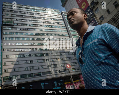 --FILE--un homme marche dernières de la Chungking Mansions dans Tsim Sha Tsui, Hong Kong, Chine, le 7 octobre 2014. Alors que les manifestations à Hong Kong continuent avec aucun signe Banque D'Images