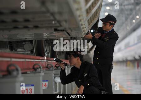 Examiner les techniciens chinois (CRH China railway High-speed) bullet trains d'Guiguang (Guiyang-Guangzhou) ligne ferroviaire à grande vitesse à un poste de maintenance Banque D'Images