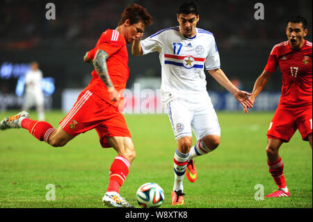 Zhang Linpeng de Chine, gauche, défis Christian Ovelar du Paraguay au cours d'un match de football amical à Changsha city, Hunan province du centre de la Chine Banque D'Images