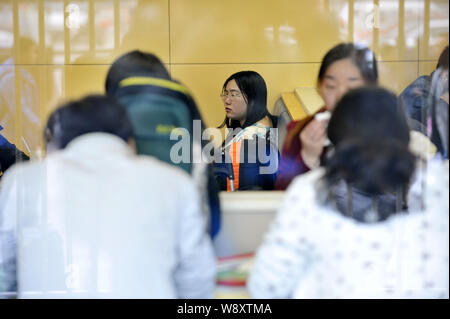 Le 26-year-old femme chinoise Tan Shen, centre, qui a rompu avec son petit ami et a vécu dans un restaurant KFC pendant une semaine, repose au fast-food o Banque D'Images