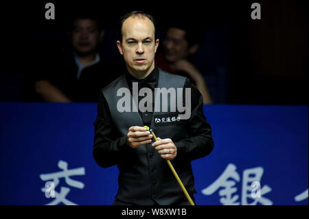 Fergal O'Brien de l'Irlande les craies son cue qu'il estime une tourné contre Mark Selby, d'Angleterre, au cours de leur du match quart monde 2014 Snooke Banque D'Images