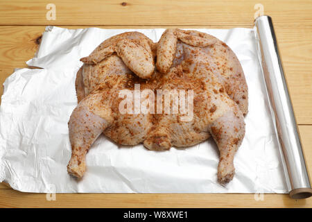 L'ensemble le poulet cru est couvert avec la marinade et l'assaisonnement sur une plaque avant la cuisson . Banque D'Images